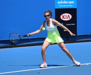 A tennis player prepares to swing at the ball