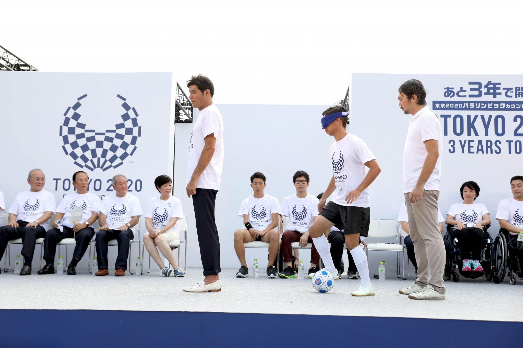 A blind footballer weaves between two people