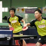 Two table tennis players are captured mid-shot