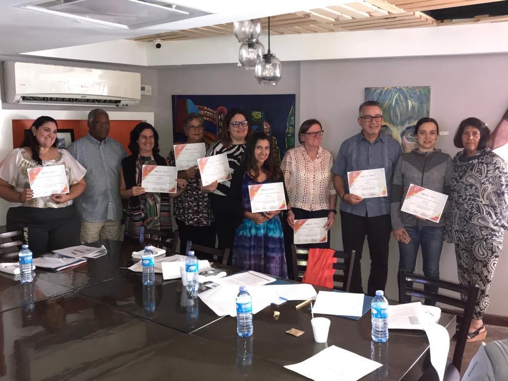 A group photo of people holding certificates for passing an eligibility workshop