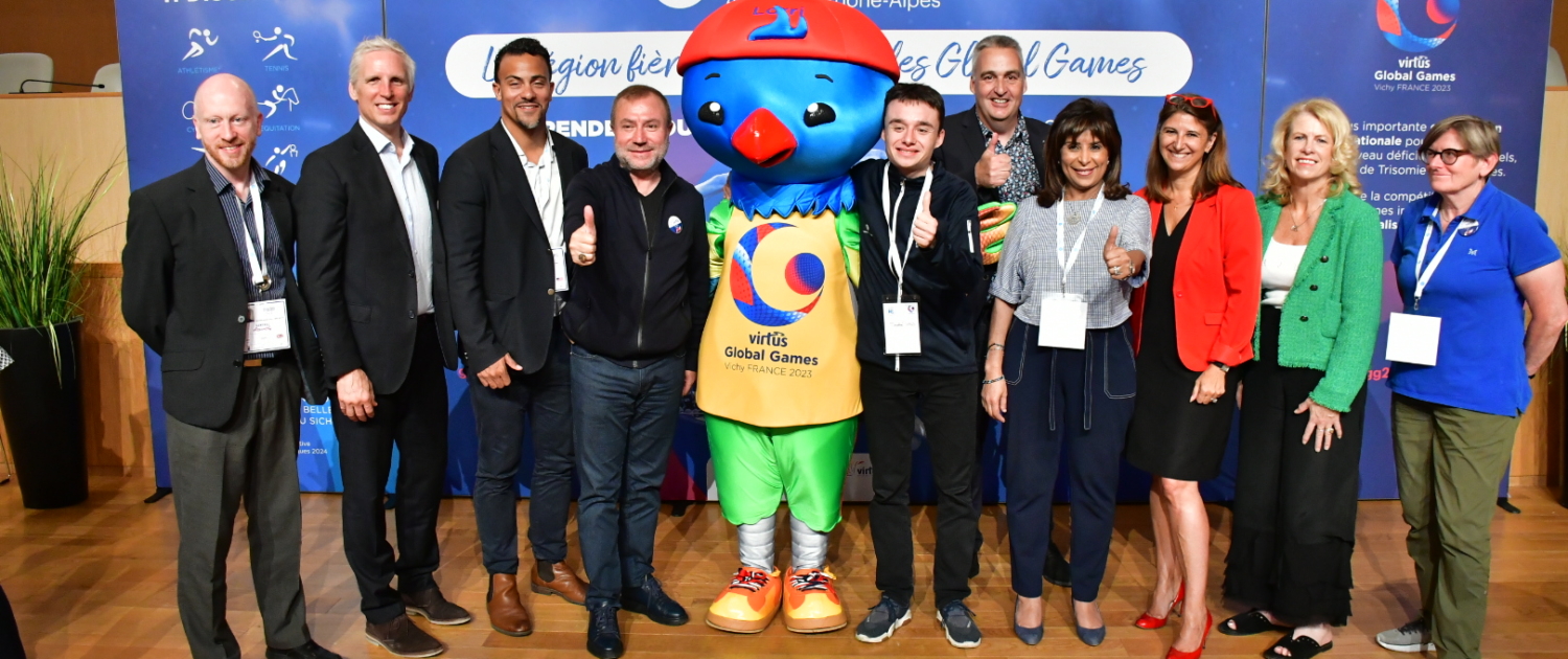 Group of people representing Virtus Global Games and La Region surround Lorri the Lorikeet mascot