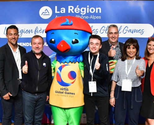 Group of people representing Virtus Global Games and La Region surround Lorri the Lorikeet mascot