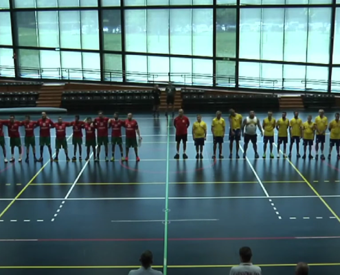 Handball players standing shoulder to shoulder standing on a handball court